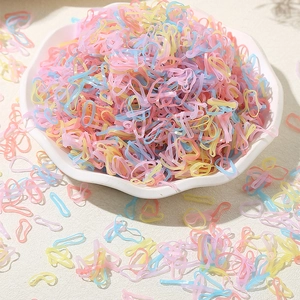 Colorful macaron elastic hair bands set for toddlers in a white porcelain dish