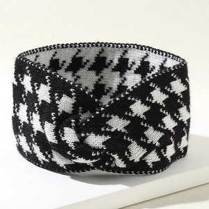 Knit houndstooth headband with cross-knot design on white display stand