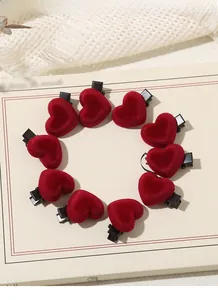 Detailed view of ten red flocked heart-shaped hair clips arranged in a circular pattern