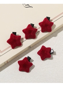 Detail view of five red velvet star-shaped hair clips with secure black metal duckbill base