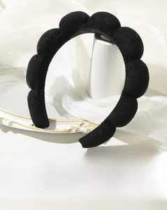 Close-up of thick black cloud headband with wave design and plush velvet texture