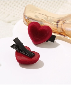 Detailed view of red velvet heart hair clips with black metal alligator base for women