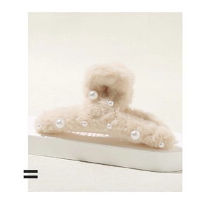 Dettaglio della pinza per capelli in peluche beige con perle finte su base bianca