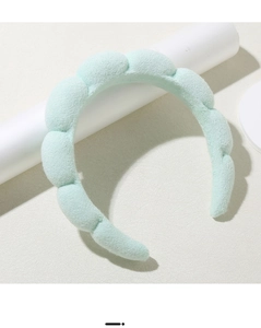 Close-up of mint green padded cloud headband in soft terry cloth fabric