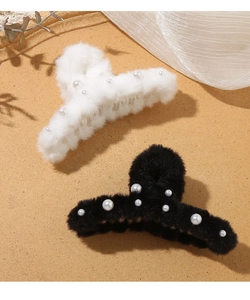 Dettaglio di fermagli per capelli in peluche bianco e nero con eleganti perle finte