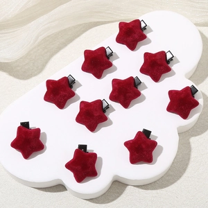 Set of 10 red star-shaped velvet hair clips on a white display board with silk fabric