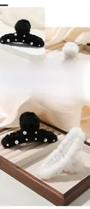 Dettaglio di mollettoni per capelli in peluche con perle su seta e vassoio in legno