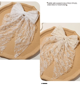 Detailed embroidery on lace bow hair clips in white and beige with elegant long ribbons