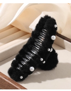 Dettaglio dell'elegante molletta per capelli in peluche nera con accenti di perle