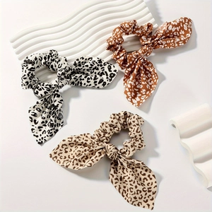 Set di tre elastici per capelli con fiocco maculato e nastri su sfondo bianco puro