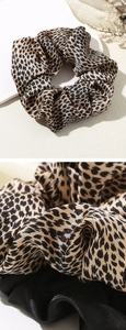 Gros plan détaillé d'un chouchou en satin léopard avec texture soie et finition brillante