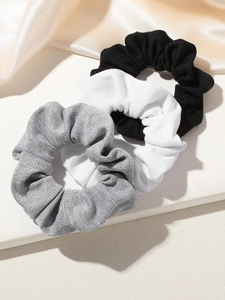 Three-piece set of knitted ribbed scrunchies in black, white, and grey with soft texture