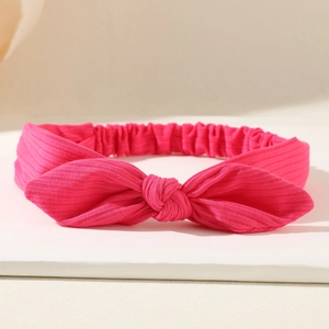 Detailed view of magenta textured bow headband with elastic band and soft ribbed fabric
