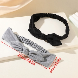 Detail view of black and grey elastic wide headbands with ribbed texture and size markings