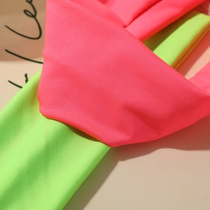 Makro-Detail von hochelastischen neonpinken und neongrünen Stoffstrukturen