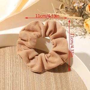 Close-up of a 4.33-inch brown ribbed fabric scrunchie on a warm decorative tray