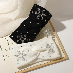 Detail eines Strickstirnbands mit glitzernden Schneeflocken und gedrehtem Wollmuster
