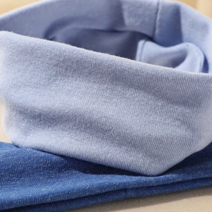 Close-up of dual-tone blue knitted fabric showing the detailed ribbed texture and elasticity