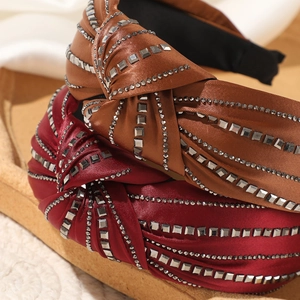 Macro shot of satin knot headbands with rhinestones in caramel brown and burgundy