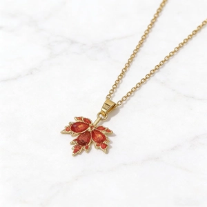 Elegant gold maple leaf pendant necklace with vibrant orange rhinestones for women