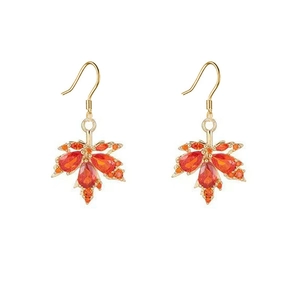 Close-up of maple leaf drop earrings with orange and red rhinestones in gold finish