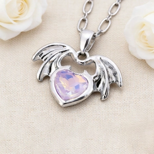 Collier avec pendentif cœur ailé et pierre violette sur fond décoré de roses blanches