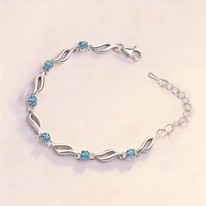 Elegant wavy silver bracelet with six round blue crystals and adjustable lobster clasp