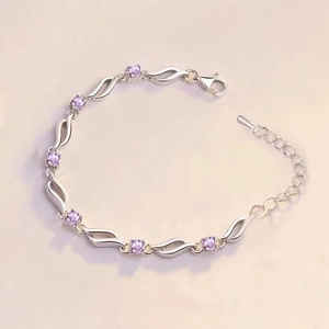 Detailed macro view of wave-shaped silver bracelet with purple round zircon and lobster clasp