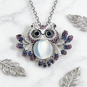 Macro shot of owl pendant featuring blue crystals and a central moonstone gemstone