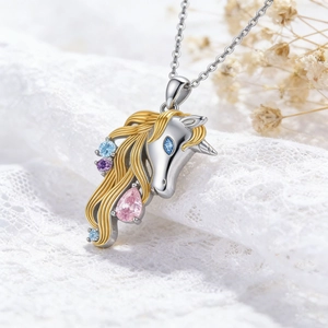 Silver unicorn necklace with gold mane and colorful crystals on lace floral background
