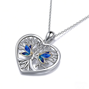 Gros plan du pendentif cœur argenté avec l'arbre de vie et des papillons en émail bleu
