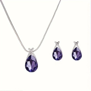 Macro detail of tear drop purple crystal necklace and earrings set with silver finish