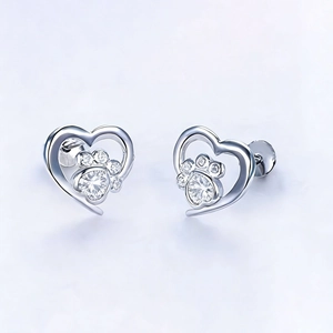 Detailed view of silver heart stud earrings with sparkling cubic zirconia dog paw motif