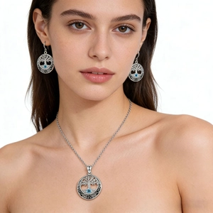 Close-up of gothic Tree of Life jewelry set with blue gemstone on a female model