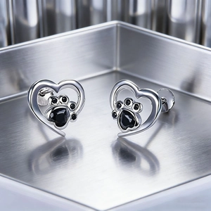 Fashionable silver heart stud earrings featuring cute black paw print design for women