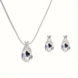 Macro shot of silver water drop necklace and earrings set with faceted blue crystals