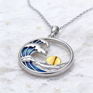 Dettaglio del ciondolo sole e onde con smalto blu su pizzo con perle bianche decorative