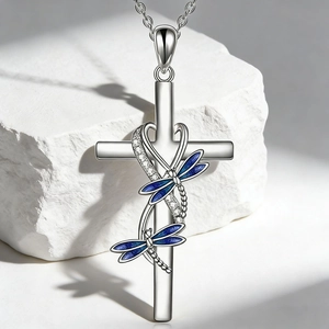 Detalle del collar de cruz plateada con libélulas de esmalte azul y cristales finos