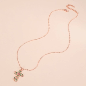 Detail of rose gold cross necklace with floral pattern and colored crystal inlays