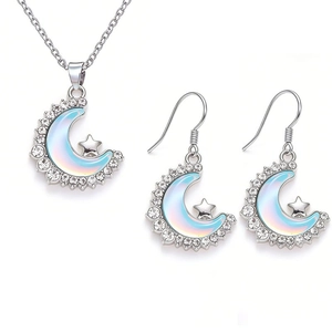 Detail of silver crescent moon jewelry set with sparkling crystals and blue star charms
