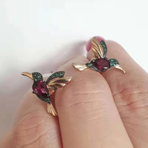 Dettaglio dell'orecchino colibrì con cristallo viola e pietre preziose verdi pavé