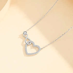 Collana cuore infinito minimalista in argento con zirconi su sfondo beige chiaro