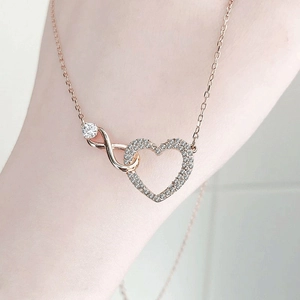 Dettaglio della collana cuore infinito in oro rosa con diamanti brillanti su donna