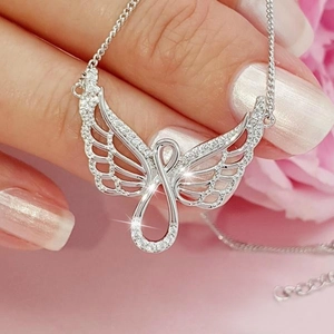 Elegant silver angel wing infinity pendant necklace with cubic zirconia on a hand