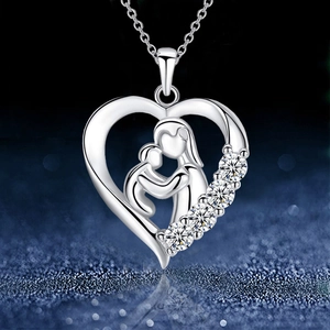 Silver mother and child heart necklace with sparkling crystals on star-themed background