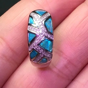 Anillo cruzado de plata con ópalo azul y circonita púrpura en primer plano