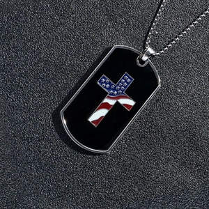 Close-up of dog tag pendant with black enamel and American flag cross on steel chain