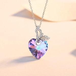 Macro detail of heart-shaped purple crystal pendant with fishtail clasp and silver chain