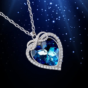 Elegant infinity heart necklace with blue crystal and diamond accents in silver frame