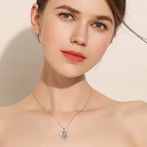 Rose gold heart necklace with iridescent crystal and small diamonds on a model